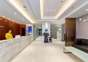 a woman standing at a counter in a lobby at City Comfort Inn Guilin Two Rivers and Four Lakes Sun and Moon Shuangta in Guilin