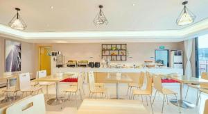 a room with tables and chairs and a kitchen at City Comfort Inn Guilin Two Rivers and Four Lakes Sun and Moon Shuangta in Guilin