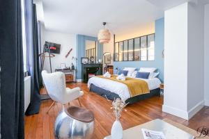 a bedroom with a bed and a table and a chair at La Demeure Numéro 5 in Cambrai