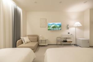 um quarto de hotel branco com uma cama e um sofá em MOREN Seoul Myeongdong em Seul