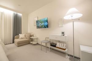 uma sala de estar branca com um sofá e uma cadeira em MOREN Seoul Myeongdong em Seul