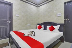 a bedroom with a bed with a red and white blanket at Super Hotel O Ashoka Classic Near Gokul Chat in Hyderabad
