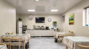 a room with tables and chairs and a tv on the wall at City 118 Selected Hotel Xi'an Fengcheng Nan Road in Xi'an
