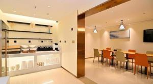 a kitchen and dining room with a table and chairs at City Comfort Inn Kunming High Speed Railway South Station Yongxin Harvard in Kunming