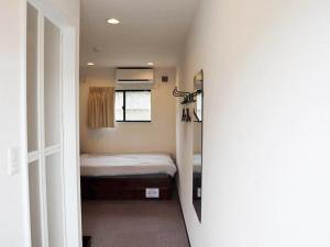 een kleine slaapkamer met een bed en een raam bij トレーラーホテル市原鶴舞インター店 in Ichihara
