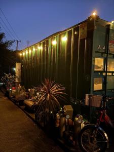 宮加三にあるThe Basecamp Yugawara - Vacation STAY 84743vのライトのついた緑色の電車の車両の隣に駐められた自転車