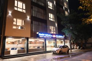 a white car parked in front of a building at Good One Suites in Bengaluru
