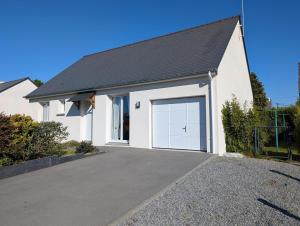 une maison blanche avec une porte de garage blanche dans l'établissement Le pre labas, à Péaule