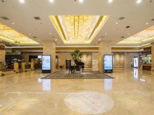 Un vestíbulo con una mesa en el medio de un edificio. en Dahe Jinjiang Hotel, en Zhengzhou