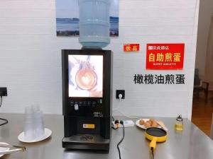 a drink dispenser sitting on a table next to a drink at Shell Hotel Chuzhou Economic Development Zone Internation Shangcheng in Chuzhou