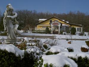 a building with a statue in the snow at Hotel Mozart in &Scaron;pi&scaron;ić-Bukovica