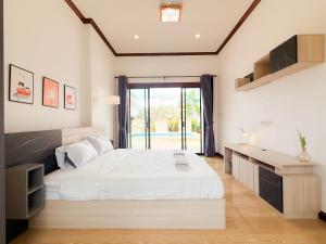 a bedroom with a white bed and a desk at Pran Suk Pool Villa pranburi  +54 photos