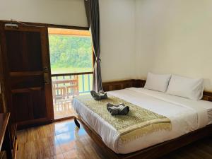 1 dormitorio con 1 cama con 2 almohadas de animales en Sabaidee Nam Ou River View, en Nongkhiaw