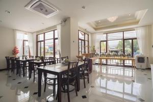 a dining room with tables and chairs and windows at The La-Ngu Boutique in Langu