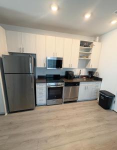 a kitchen with stainless steel appliances and white cabinets at Spacious Studio Living in Kansas City