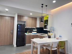 a kitchen with a white table and a black refrigerator at Republic Plaza - View sân bay, view hồ bơi in Ho Chi Minh City