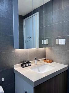 a bathroom with a sink and a mirror at Republic Plaza - View sân bay, view hồ bơi in Ho Chi Minh City