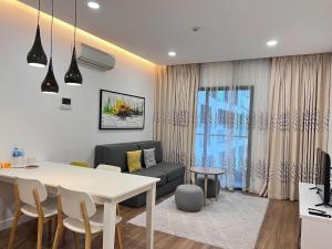 a living room with a white table and a couch at Republic Plaza - View sân bay, view hồ bơi in Ho Chi Minh City