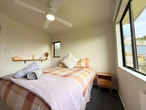 a bedroom with a bed and a window at Private Holiday Home with Harbour Views Near Whangarei CBD in Whangarei