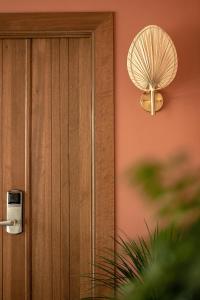 a wooden door with a fan on the wall at Laman Villa Langkawi in Pantai Cenang