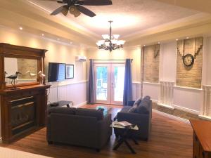 a living room with couches and a clock on the wall at Grey Rose Suites in Hanover