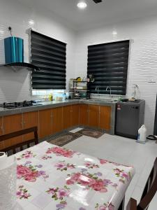 パシール・プトゥにあるANJUNG SARA Homestayのキッチン(花のテーブル付) +4枚の写真