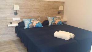a bedroom with a blue bed with blue sheets and pillows at La Chanca in Conil de la Frontera