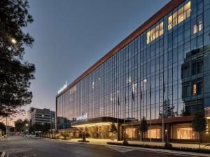 a large glass building on a city street at Swissotel Tashkent in Tashkent