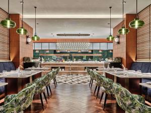 a restaurant with tables and chairs and a bar at Swissotel Tashkent in Tashkent
