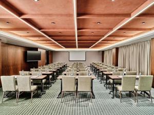 a conference room with tables and chairs and a screen at Swissotel Tashkent in Tashkent +133 photos
