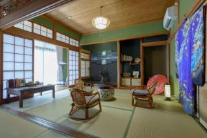 a living room with chairs and a table at ようこそ月の宿へ in Shindembaru