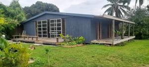 a small blue house with a yard in front of it at Mountain Breeze Rarotonga in Rarotonga