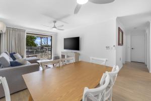 a living room with a table and a couch at Spinnaker Apt 6- Mooloolaba Beach in Mooloolaba