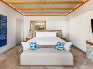 a bedroom with a bed and a couch at Fairmont Mayakoba in Playa del Carmen