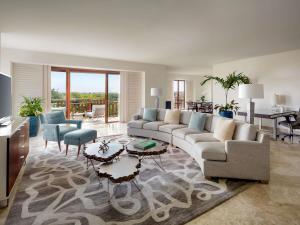 a living room with a couch and tables and chairs at Fairmont Mayakoba in Playa del Carmen +289 photos