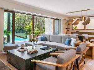 una sala de estar con un sofá y una mesa en Fairmont Mayakoba, en Playa del Carmen 280 fotos más