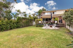 a yard with two chairs and a table in front of a house at Boomerang Bliss in Elizabeth Beach