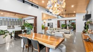 Una sala de estar con una mesa y sillas de madera. en Casa Ponta Port Douglas, en Craiglie