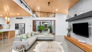 Una sala de estar con un sofá y un televisor en Casa Ponta Port Douglas, en Craiglie
