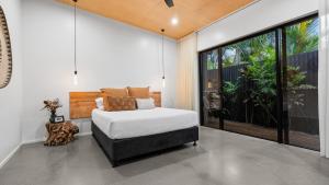 Un dormitorio con una cama y una ventana grande en Casa Ponta Port Douglas, en Craiglie