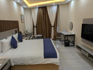 Una habitación de hotel con una cama y un televisor de pantalla plana. en Hotel Hillview Islamabad, en Islamabad
