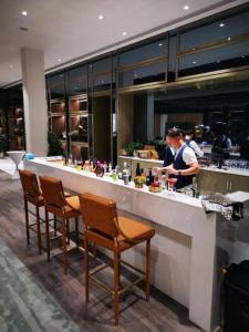 a bar in a restaurant with people preparing food at Lavande Hotel Shanghai Jing'an Shibei Gaoxin in Shanghai