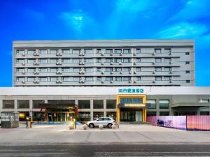 a building with a car parked in front of it at City Comfort Inn Tangshan Railway Station Lunan District Government in Tangshan