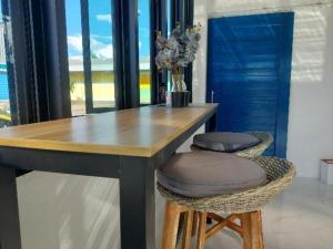 a dining table with two stools and a table with flowers at A Day Hotel in Roi Et