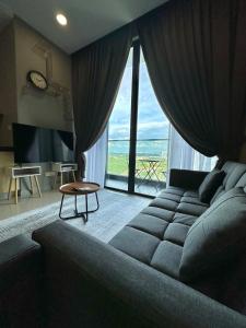 un salon avec un canapé et une grande fenêtre dans l'établissement D Pristine 4 bedder apartment 2325 opp legoland, à Iskandar Puteri