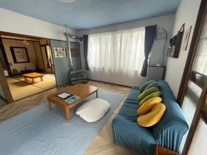 a living room with a blue couch and a table at Bear Foot 蒼 in Yakumo