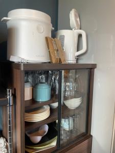a cabinet filled with dishes and a pot at Bear Foot 蒼 in Yakumo