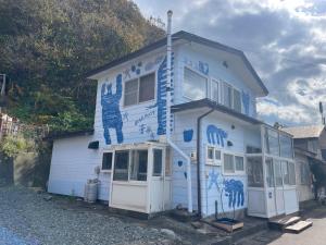 a blue and white house with graffiti on it at Bear Foot 蒼 in Yakumo