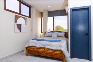 サリナスにあるYesimar Hotelの木製のベッドと青いドアのある寝室