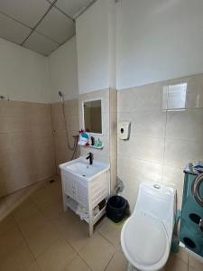 a bathroom with a toilet and a sink at TR Apartment in Honiara